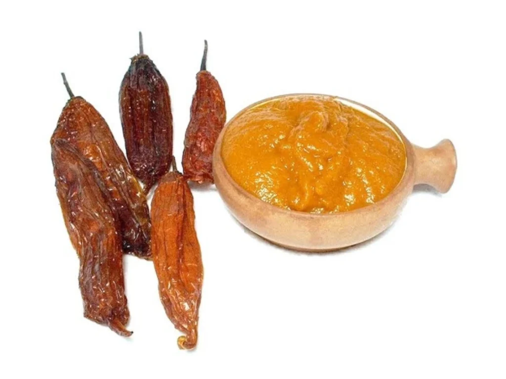 Gedroogde ají mirasol en een schaal oranje ajípasta.