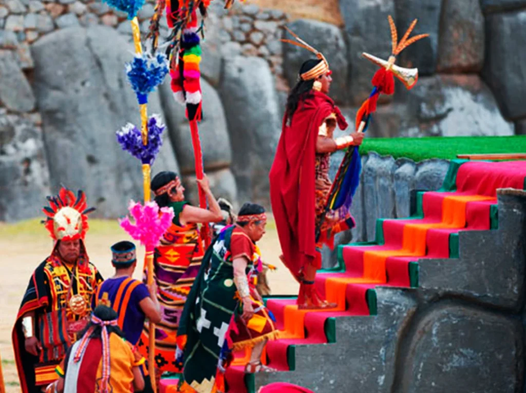 Deelnemers in Inca-kledij beklimmen een trap tijdens de naspeling van het Inti Raymi.